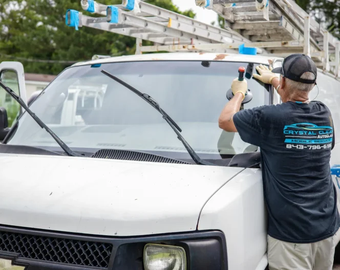 Crystal Clear Auto Glass mobile service technician setting a new windshield into place on a work van in Myrtle Beach SC